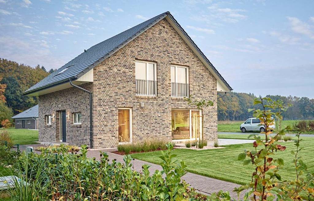 Familienhaus 140s Seitenansicht mit Haustür und umlaufender Terrasse